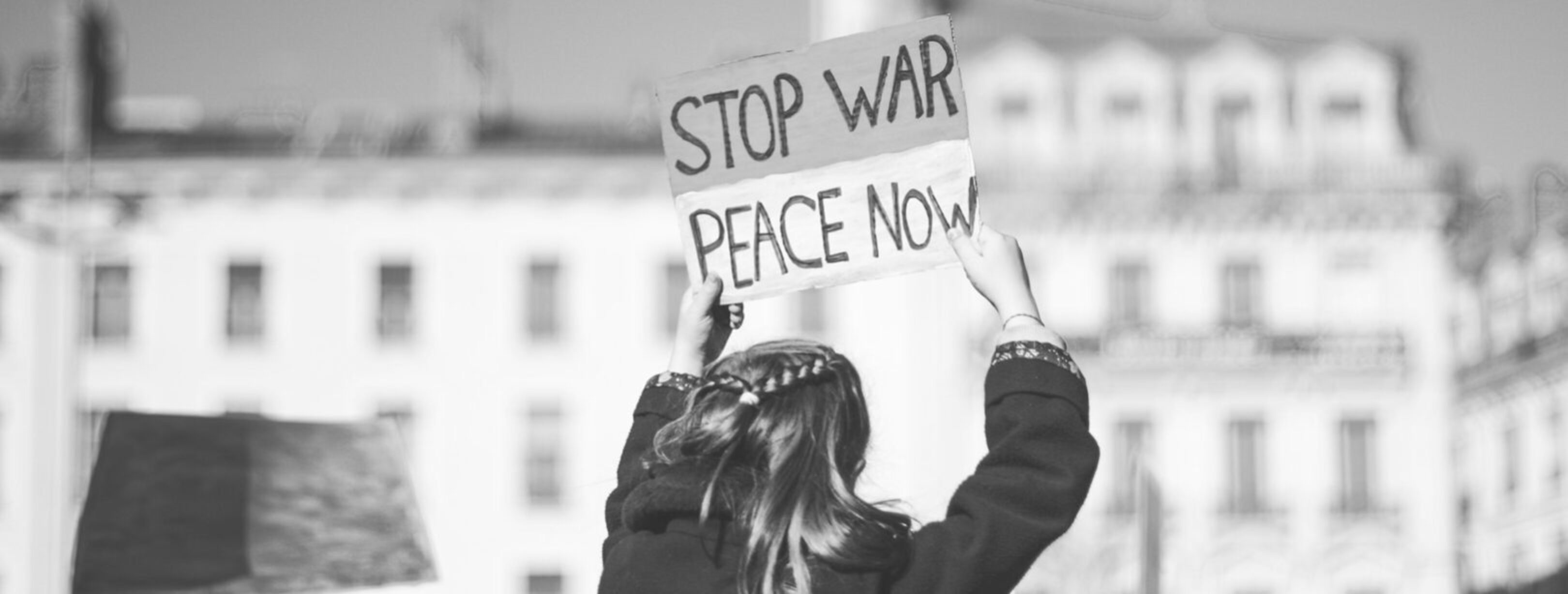 1620-ev-a woman holding a sign that says stop war peace now-unsplash